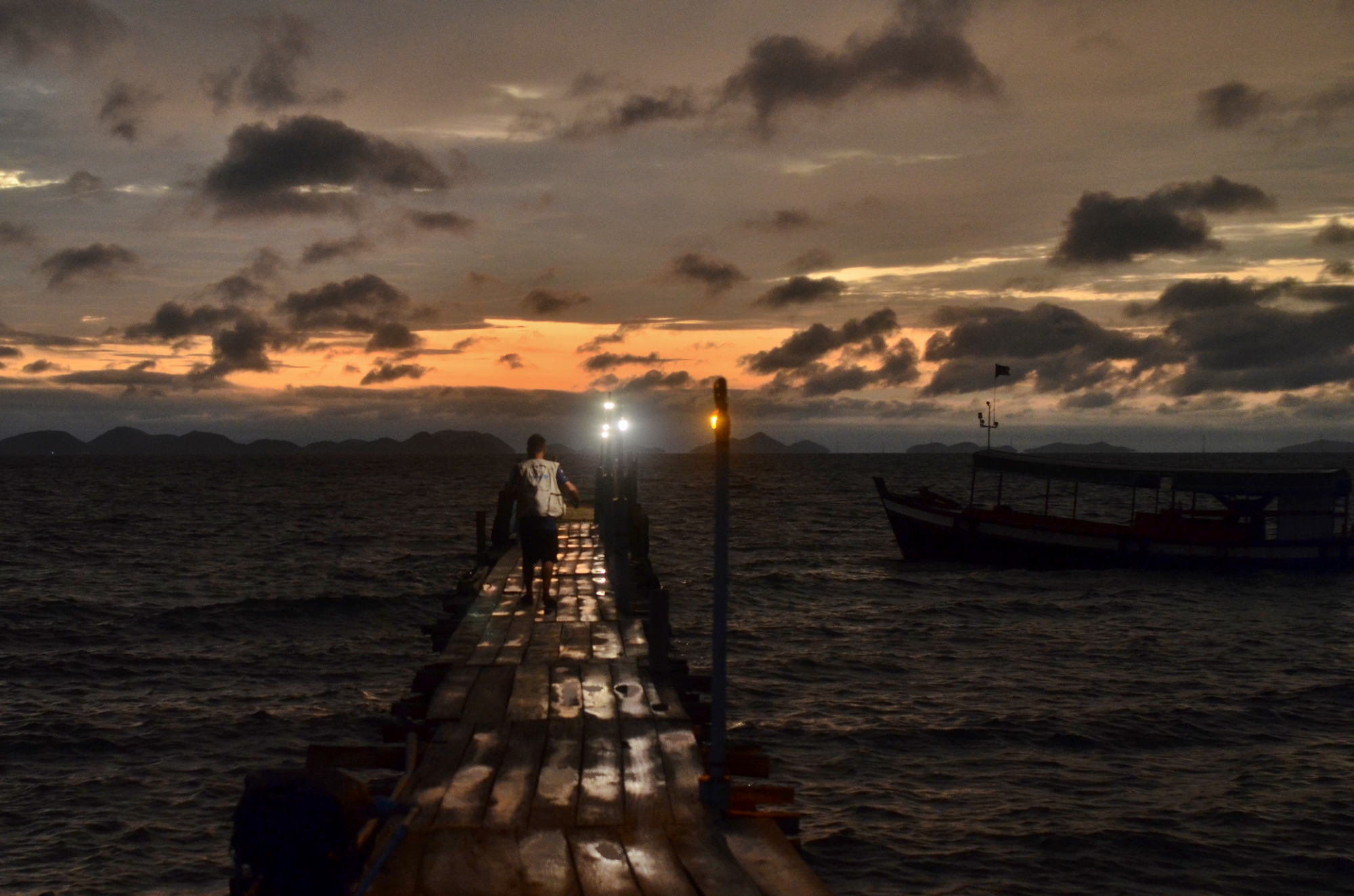 Jaime Gill from the UNICEF team walking in the Koh Ach Seh pier during sunrise.